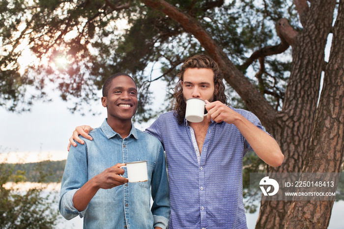 Friends drinking coffee by lake