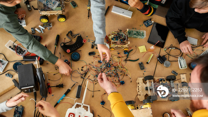 Bringing your ideas and innovations to life. Happy children working with wires, constructing diy rob