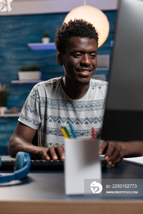 Smiling teenager entrepreneur browsing information on internet working at business project. African 