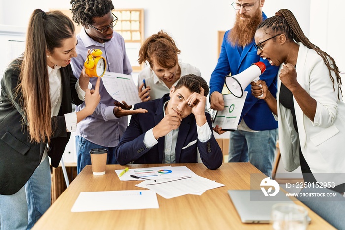 Group of business workers screaming to stressed partner at the office.