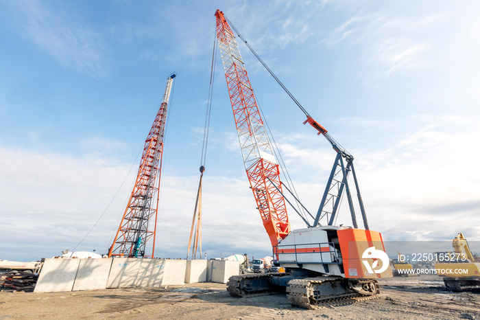 The big crawler crane and other construction machineries are working to build pier of the harbor. A 