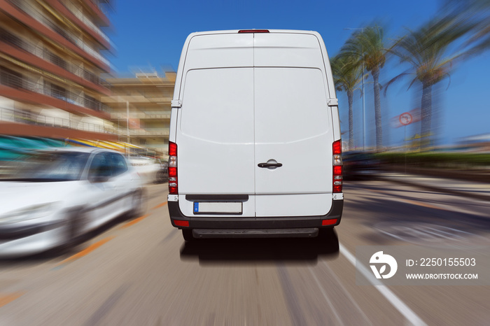 Transporter oder Lieferwagen fährt auf einer Straße bei blauem Himmel und liefert Pakete aus.