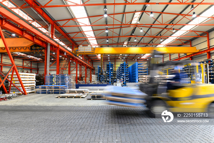 Gabelstapler in einem Stahlhandel // Interieur einer großen Fabrikhalle