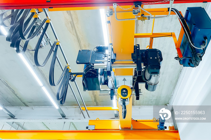 Overhead crane and machine inside factory building, industrial background.