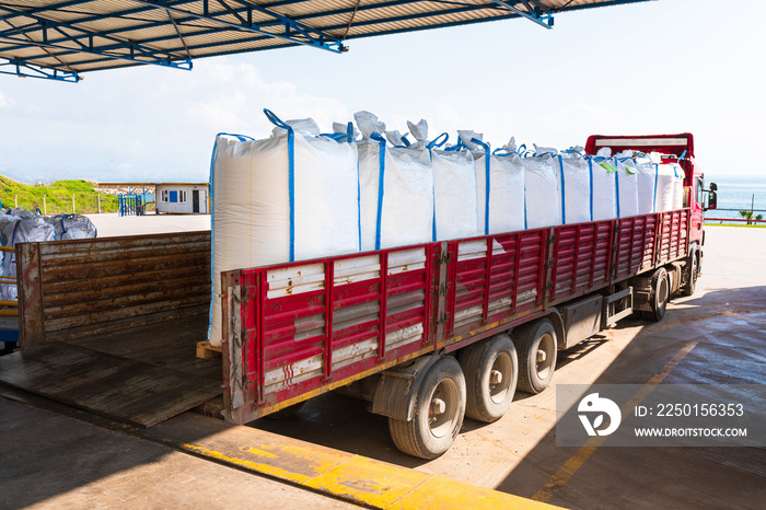 Truck loading with stack of factory products in white sack bags. Shipped factory products cargo, shi