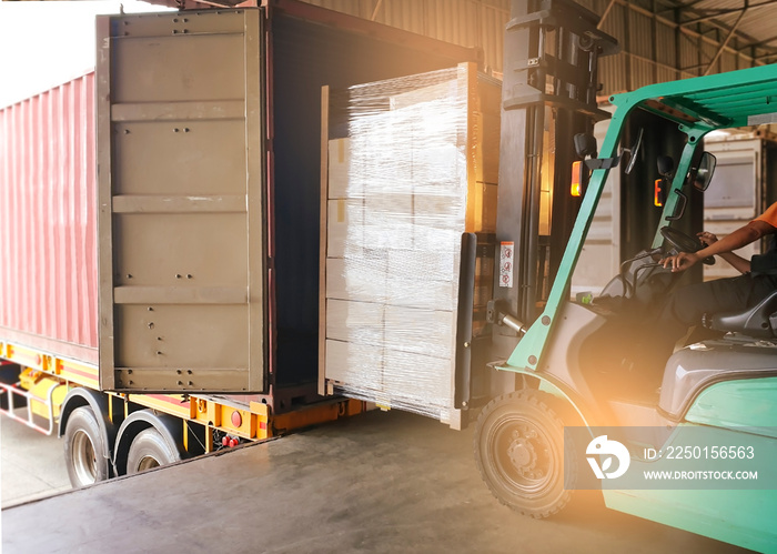 Workers Driving Forklift Tractor Loading Cargo Pallets into Container Trucks. Shipping Warehouse. De