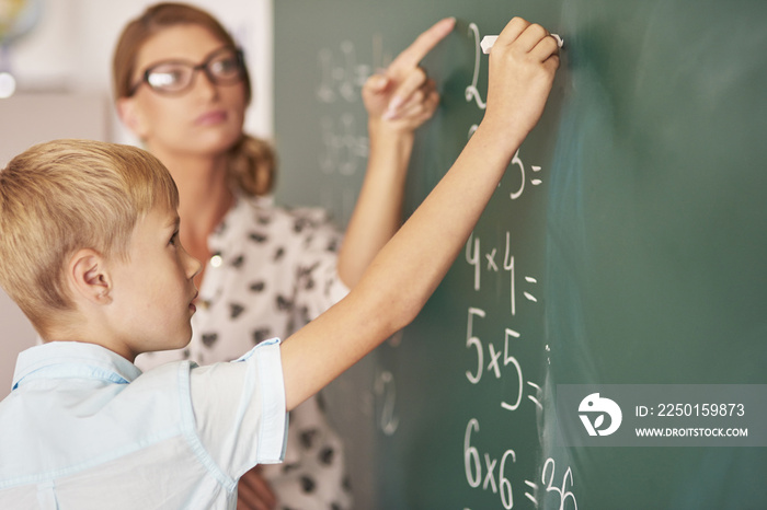 Teacher trying to help boy understand the Maths.