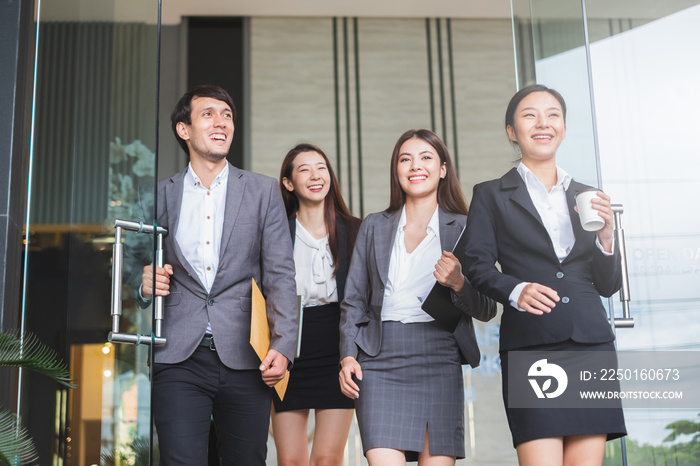 Asian business people walking and talking with colleagues in office