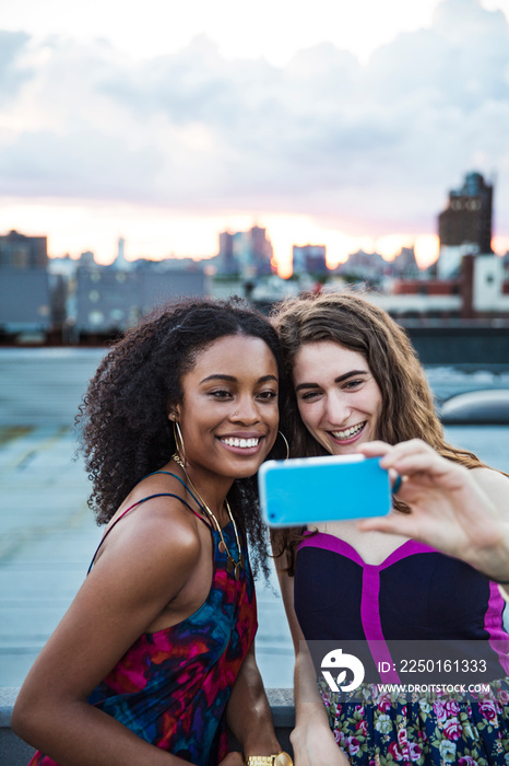 Two young women taking selfie with smart phone