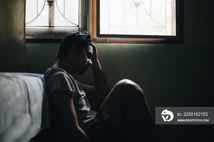 young man feeling depressed and stressed in the dark room, Negative emotion and mental health concep