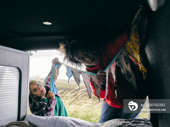 Women hanging decorations in van