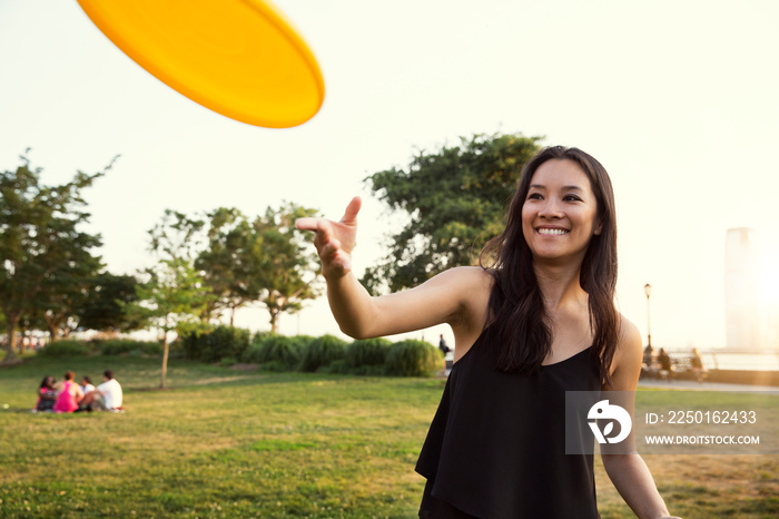 Young woman throwing plastic disc