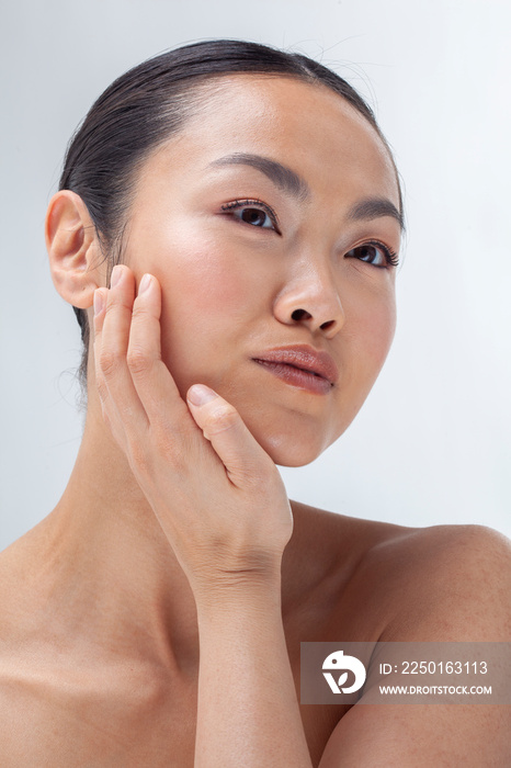 Studio portrait of woman touching face