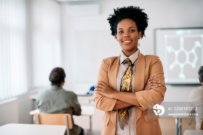 Portrait of happy confident African American teacher in classroom looks at camera.