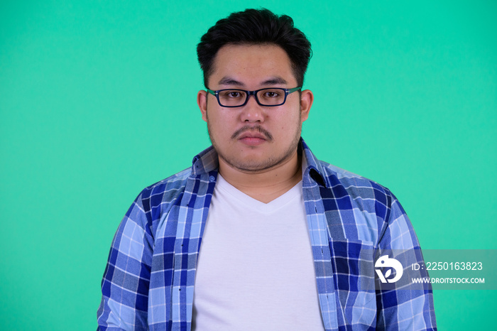 Face of young overweight Asian hipster man