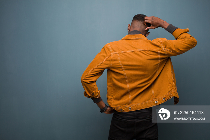 young african american black man feeling clueless and confused, thinking a solution, with hand on hi