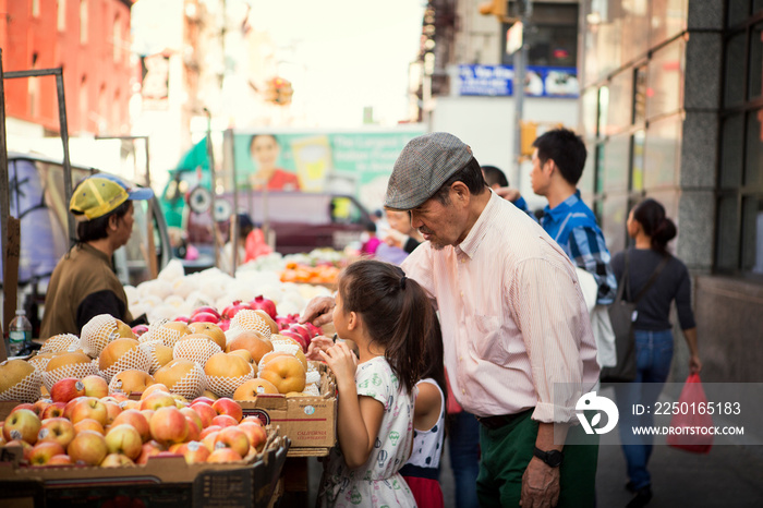 Grandfather and granddaughter shopping in market