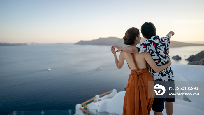 Asian Couple enjoying View Oia village in Santorini island, Greece.