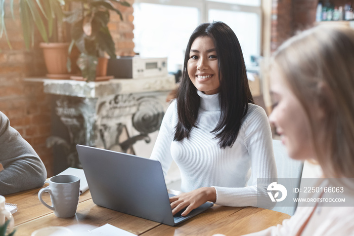 Portrait of pretty asian girl having business meeting with colleagues