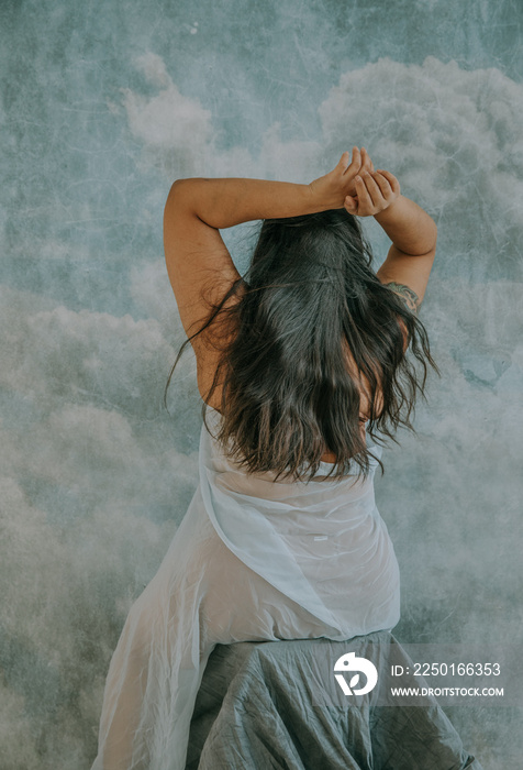 portrait of East Indian womans back of head with hands overhead