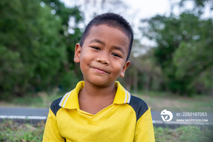 Asian poor child laughing and smile with white teeth in nature background.Close up Headshot Asian ki