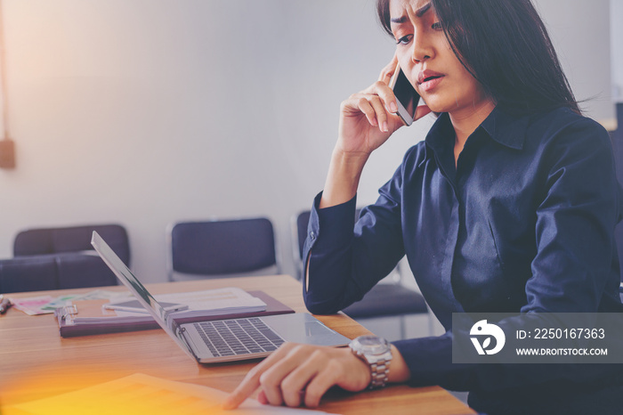 Businesswoman in black shirt talking by mobile phone in office look like serious.