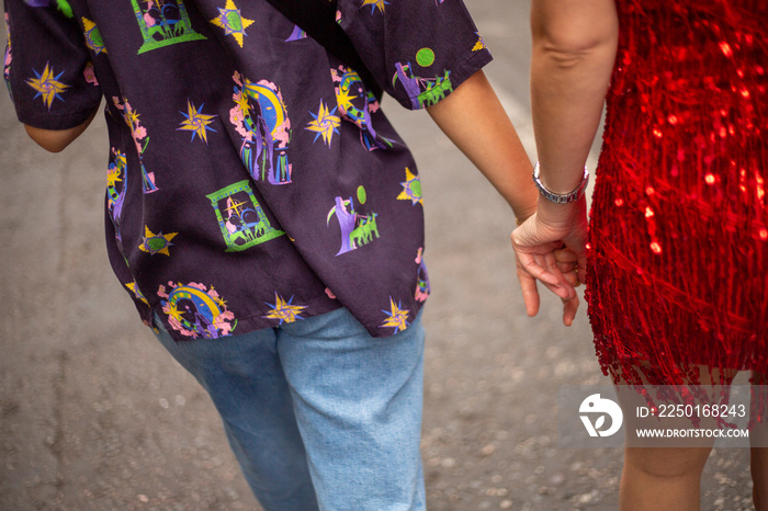 Mid section of two women holding hands