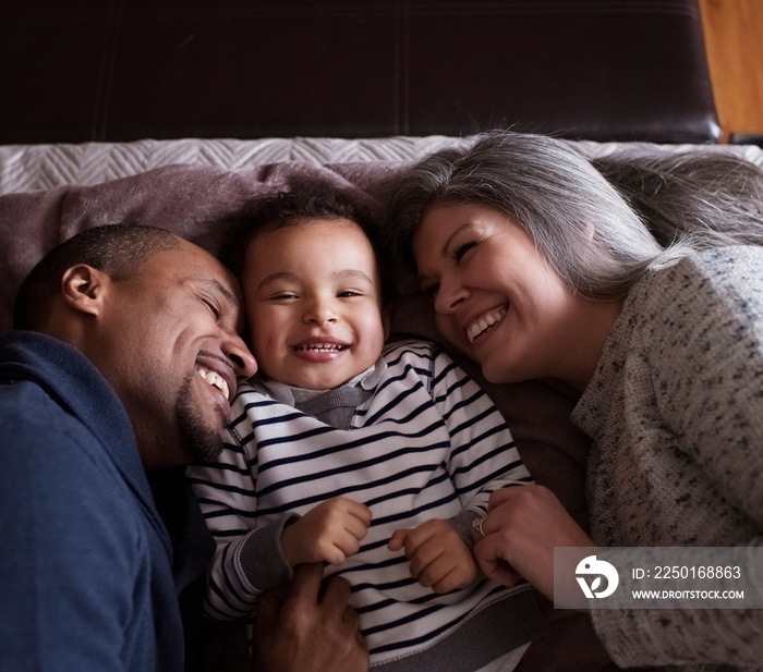 Happy family lying on bed at home