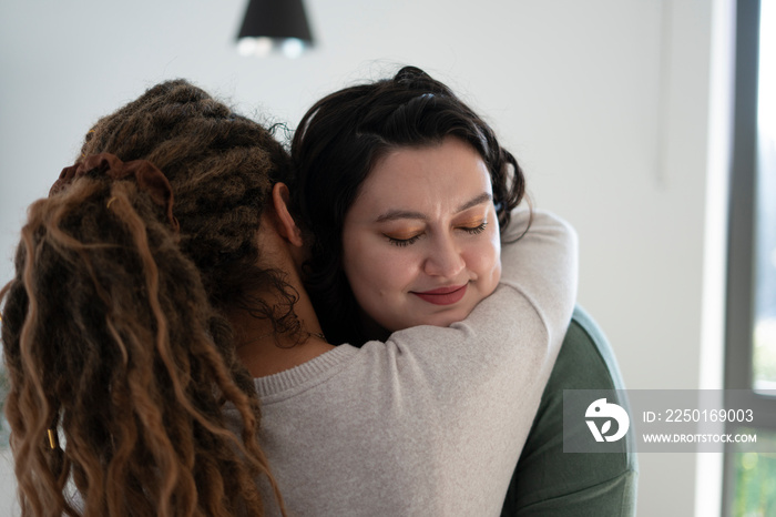 Two women embracing at home