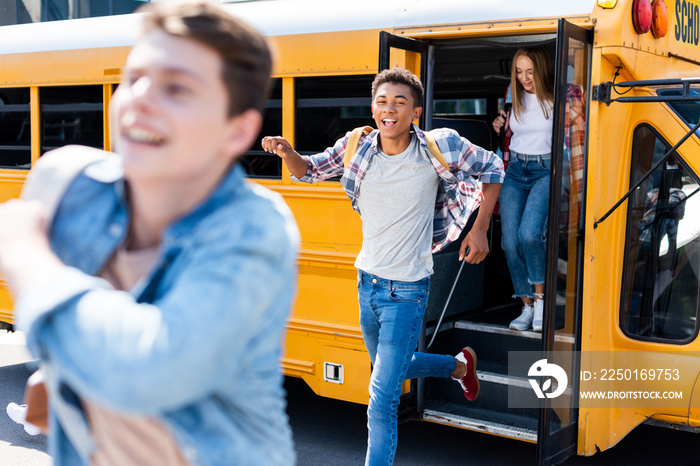 group of teen students running out of school bus