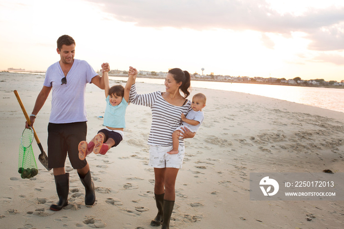 Family with two children (0-1 month, 2-3 years) on beach