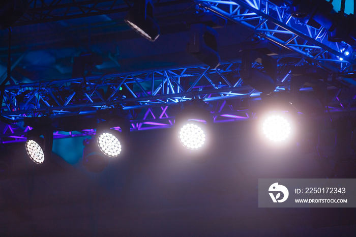 row of stage lights, dark blue background, stage spotlights