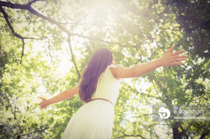 Low angle view of long hair woman with arms outstretched