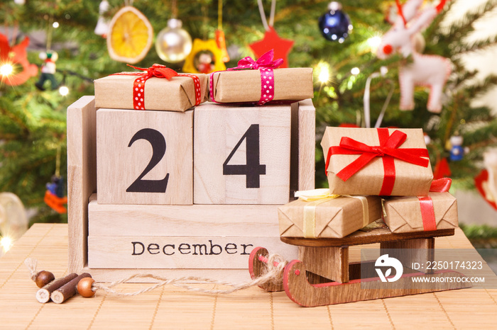 Date 24 December, gifts with sled and christmas tree with decoration, Christmas eve time concept