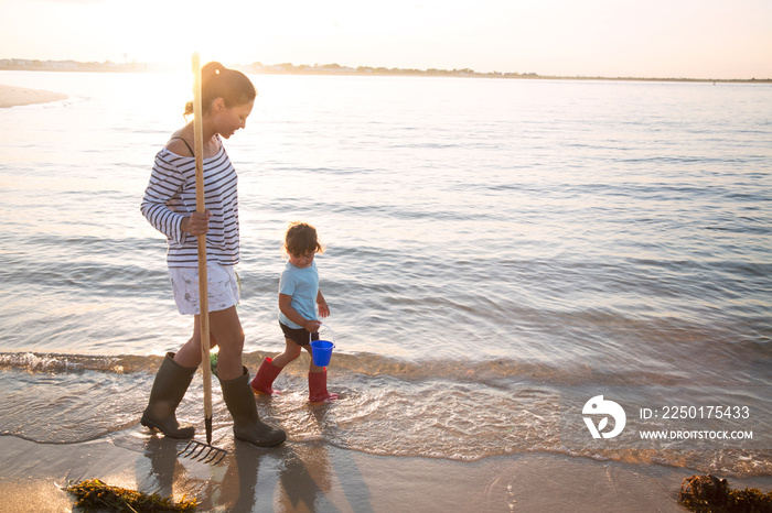 Mother and daughter (2-3) on beach