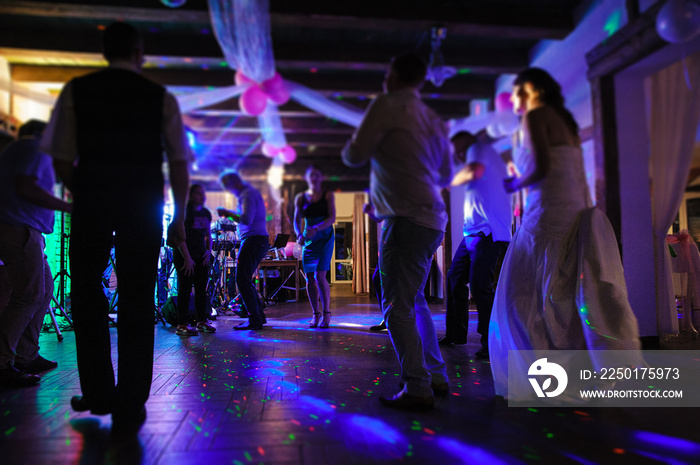 Bride and groom dancing the first dance at their wedding day. Guest on the dancefloor.