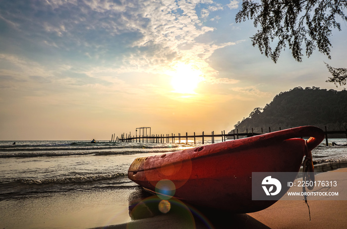 Boat and pier on the beach at sunset time