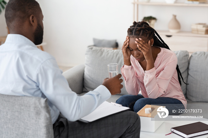 Psychologist Comforting Depressed Black Woman During Mental Therapy Session At Office