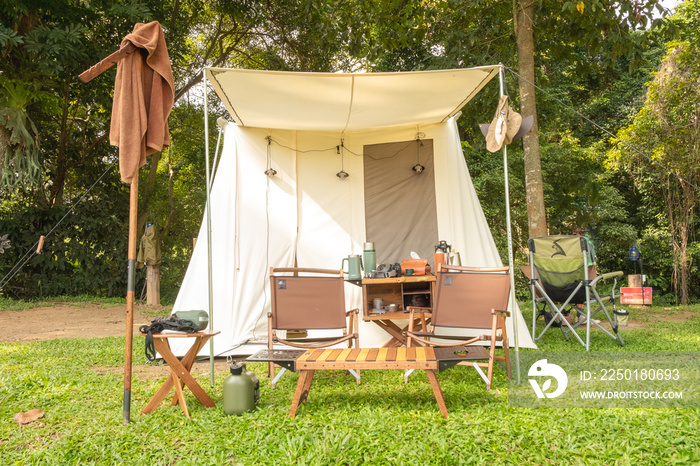 A white teepee tent with glamping interiorwith desk and chairs at the campsite in forest,holidayvaca