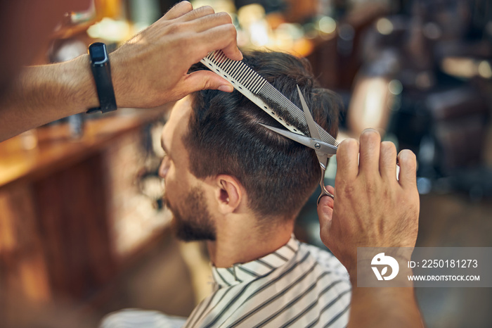 Young man having his hair cut and styled at a salon