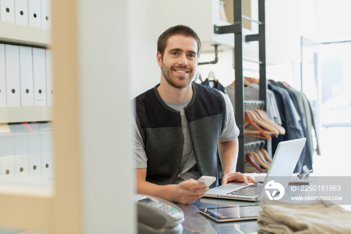 Bearded clerk with laptop, pc tablet and cell phone at desk