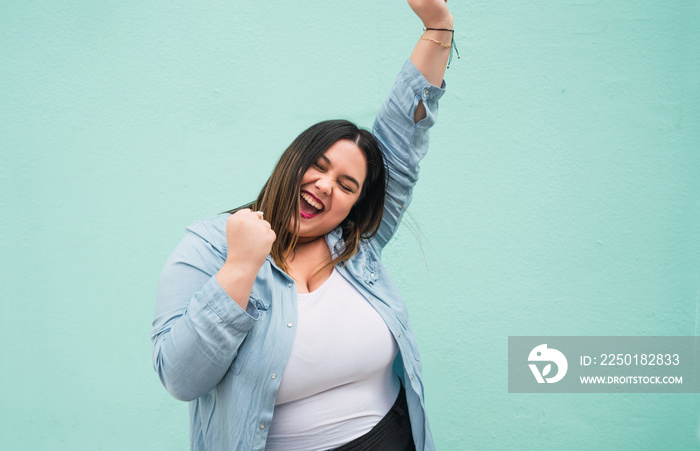 Young plus size woman celebrating victory.