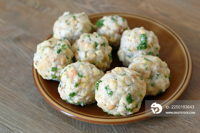 Hausgemachte Semmelknödel mit Petersilie auf dem Teller.