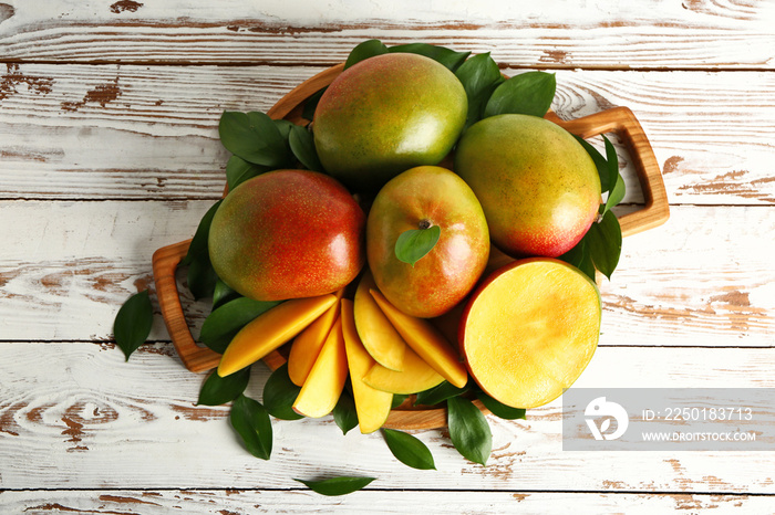 Board with tasty fresh mango on wooden table