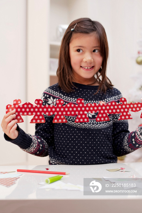 Girl holding Christmas decoration, smiling