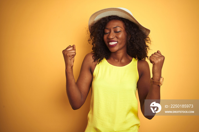 Young african american woman wearing t-shirt and hat over isolated yellow background very happy and 