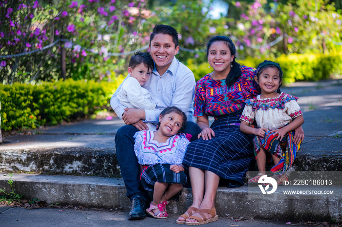 Familia hispana disfrutando de la naturaleza en el parque. Padres jóvenes con sus hijos al aire libr