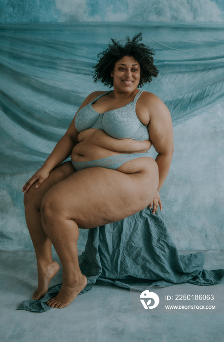 portrait of a plus size afro indigenous person sitting and smiling