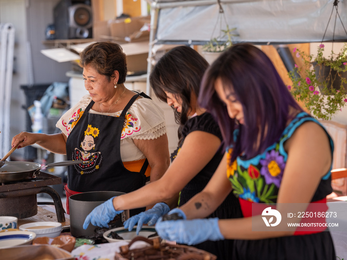 Horizontal image of Indigenous woman preparing Indigenous foods with gloves