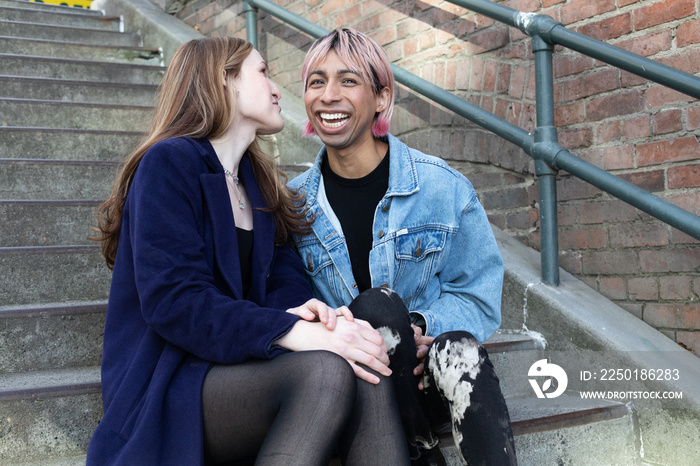 Lgbtqia friends posing on stairs outside.